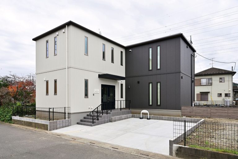 白とグレーの外観に映える、サロン併用のモダン邸宅